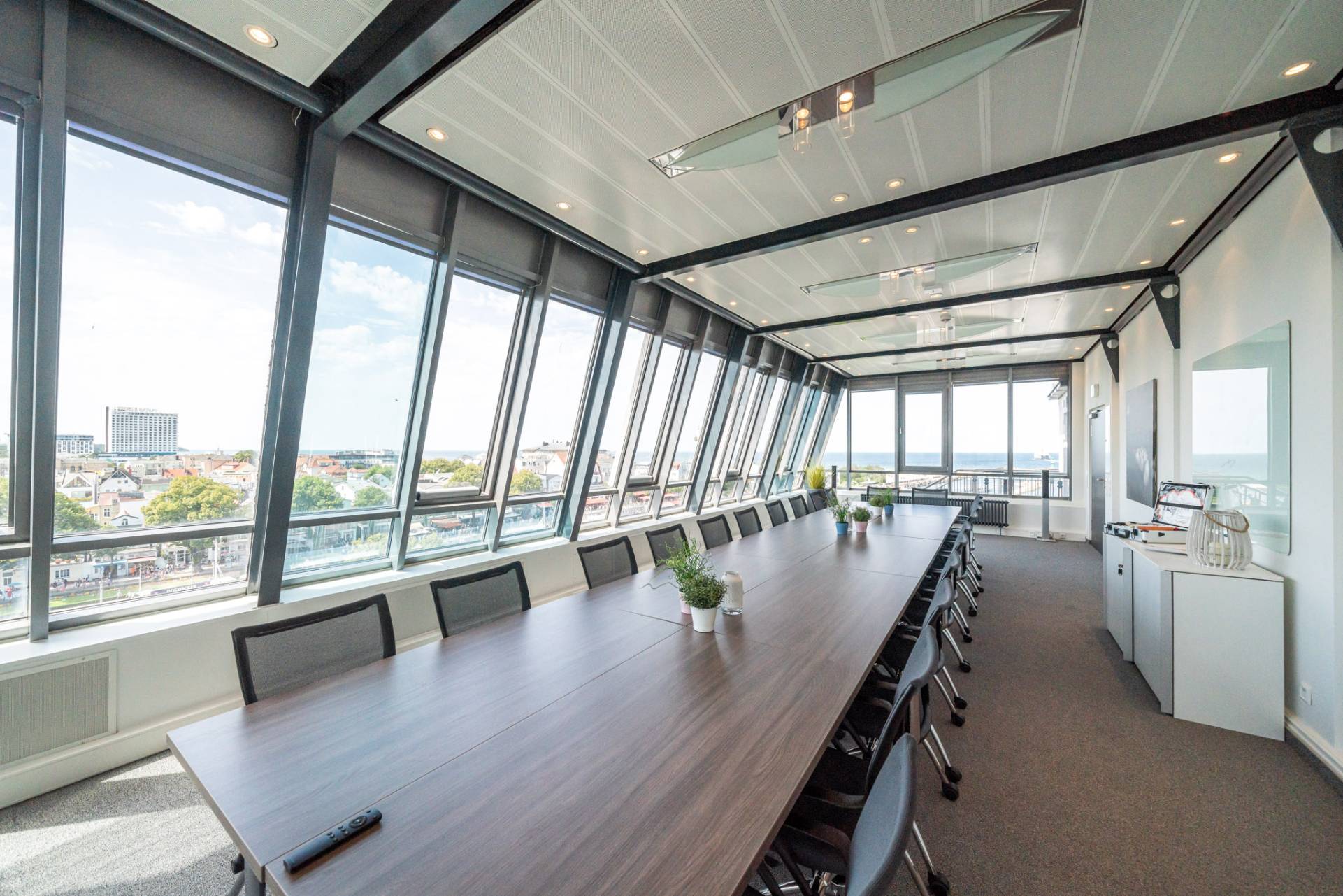Konferenzraum mit langem Tisch und großer Fensterfront mit Ausblick